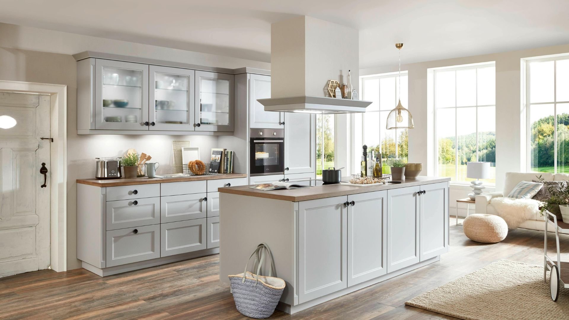 Modern white kitchen with wooden countertop, island, and large windows